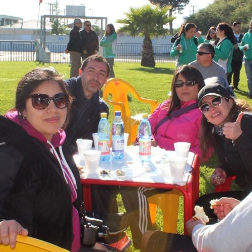 A group of people sitting at a table with water bottles in a park
