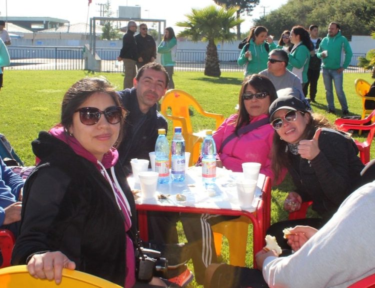A group of people sitting at a table with water bottles in a park