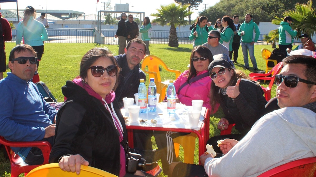 A group of people sitting at a table with water bottles in a park
