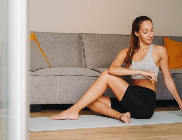 Woman practicing yoga indoors on a mat, embodying fitness and tranquility.